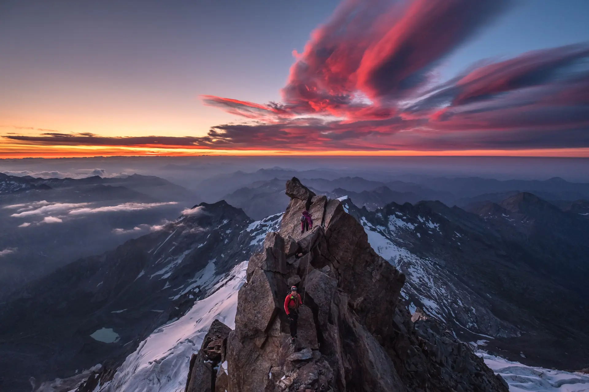Bergsteiger auf dem Grat der Cresta Signal im Monte-Rosa-Massiv, Wallis, Schweiz, kurz vor Sonnenaufgang.