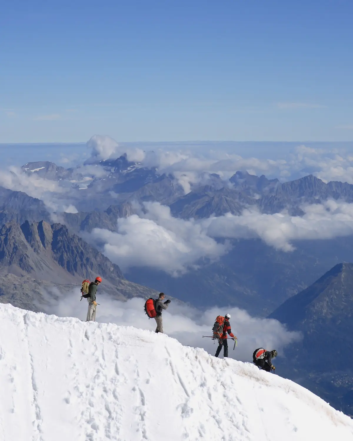 Bergsteigerinnen und Bergsteiger mit Seil verlassen die Bergstation der Aiguille du Midi oberhalb von Chamonix, Frankreich.