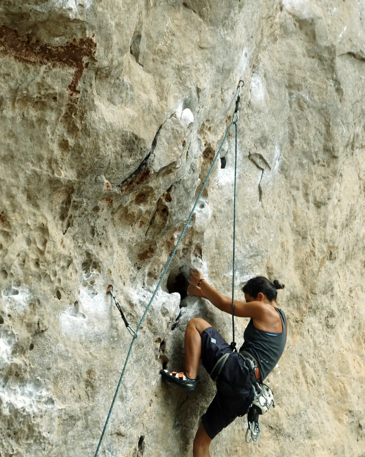Kletterin an einer überhängenden Kalkwand am Strand Phra Nang, Krabi, Thailand.